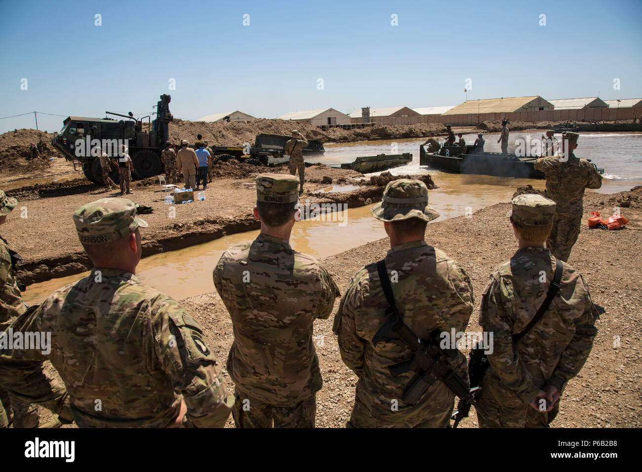 Stati Uniti Esercito Brig. Gen. John E. Novalis II, vice comandante generale per il supporto combinato di forze congiunte terra comando di componente - Funzionamento inerenti risolvere, il secondo da sinistra e membri del 502nd Multi Roll società Ponte guardare come un ponte galleggiante viene posto in acqua durante un esercizio di formazione presso il Camp Taji, Iraq, 21 aprile 2016. Gli iracheni e le forze americane attivamente il treno sulla barca-manovra e ponte-tecniche di costruzione per mantenere critici di linee di comunicazione e di comportamento fissi e ponte galleggiante operazioni. La formazione a costruire la capacità del partner sites è parte integrante della produzione combinata di Jo Foto Stock