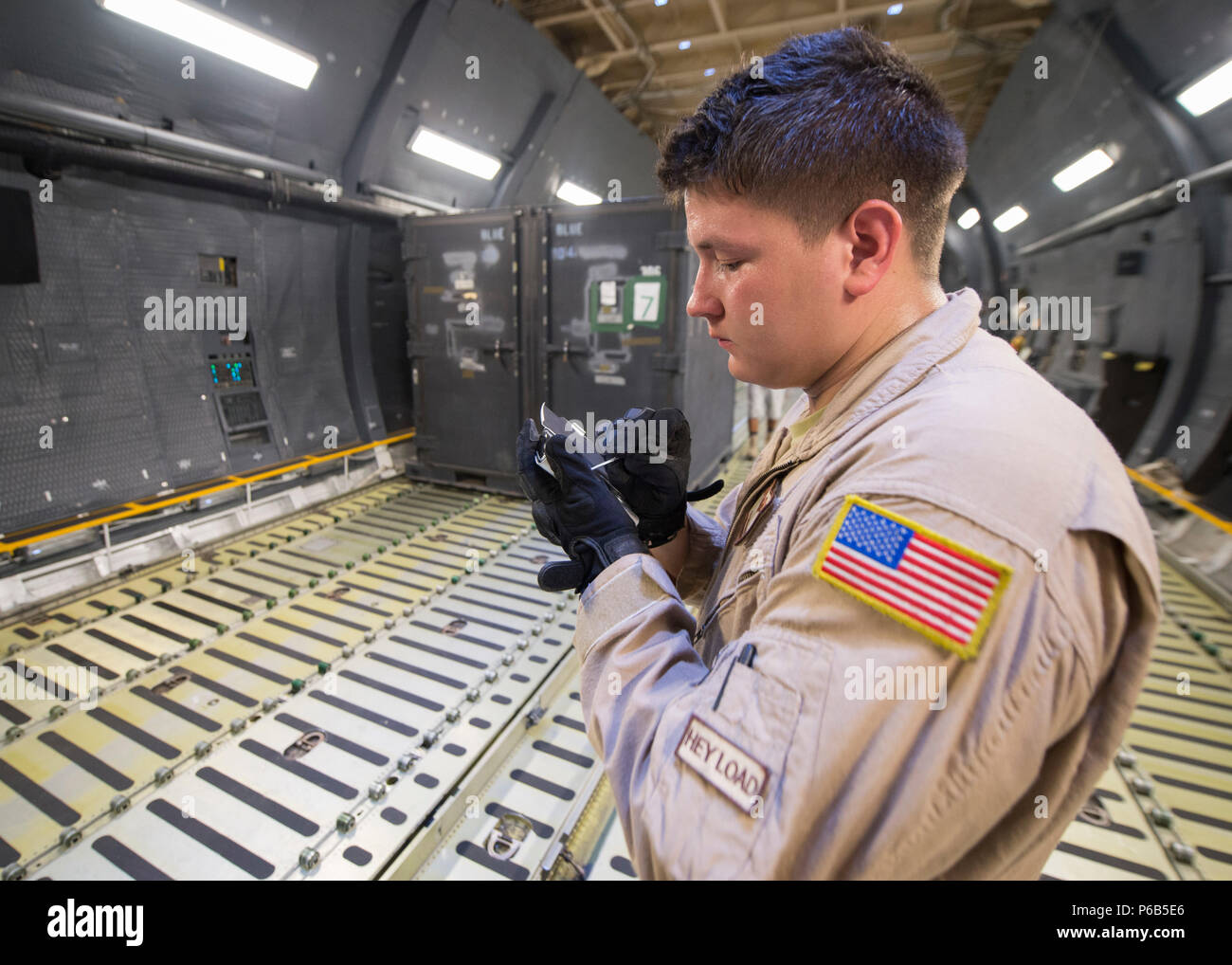 Senior Airman loadmaster del 9th Airlift Squadron calcola il peso e l'equilibrio utilizzando un assistente digitale personale durante il carico a Camp Lemonnier, Gibuti, il 31 maggio 2016. L'equipaggio di 11 membri circumnavigò il globo in due settimane utilizzando il C-5M Super Galaxy, alimentato da quattro motori GE CF6-80C2. L'aeromobile trasportava merci, elicotteri e personale di grandi dimensioni a livello globale, supportando le missioni strategiche di trasporto aereo della U.S. Air Force e la prontezza operativa del 436th Airlift Wing. Foto Stock