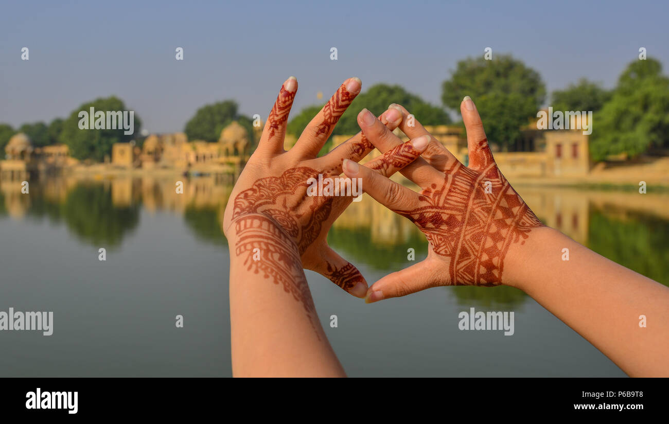 Henna Tattoo sulla donna le mani con il lago sullo sfondo della scena nella giornata di sole. Foto Stock