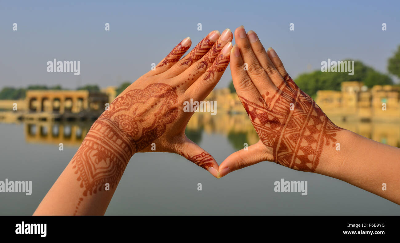 Henna Tattoo sulla donna le mani con il lago sullo sfondo della scena nella giornata di sole. Foto Stock