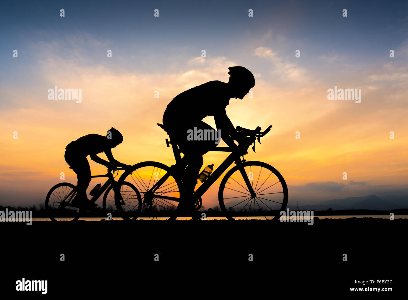 Ciclista in massimo sforzo in una strada all'aperto al tramonto Foto Stock