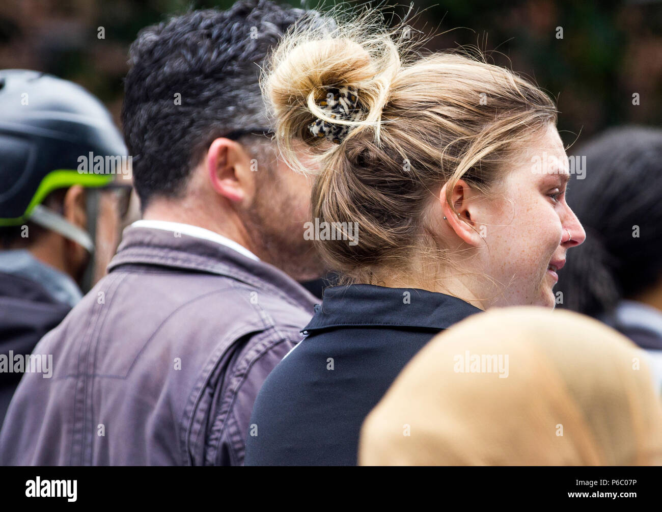 Il primo anniversario del 24 piani Grenfell a torre dell'edilizia pubblica appartamenti fire quale rivendicato 72 vive. Giovane donna che piange nel corso di un anno di servizio memoriale per le vittime dell'Grenfell torre fire, South Kensington, Londra, Regno Unito, 14 giugno 2018. Foto Stock