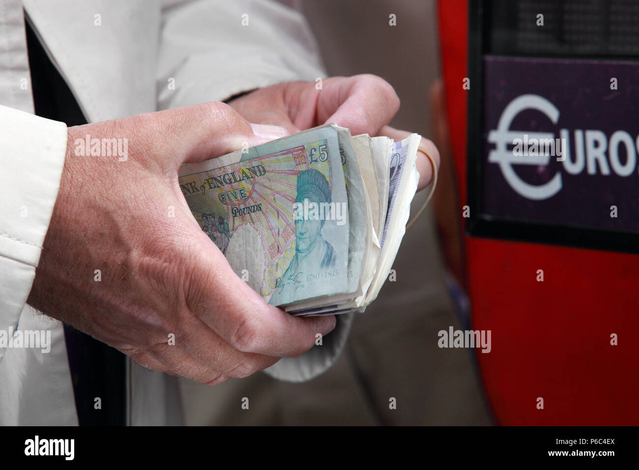 Ascot, Regno Unito, Sterlina britannica note sono detenute nella parte anteriore di un euro cambio macchina Foto Stock