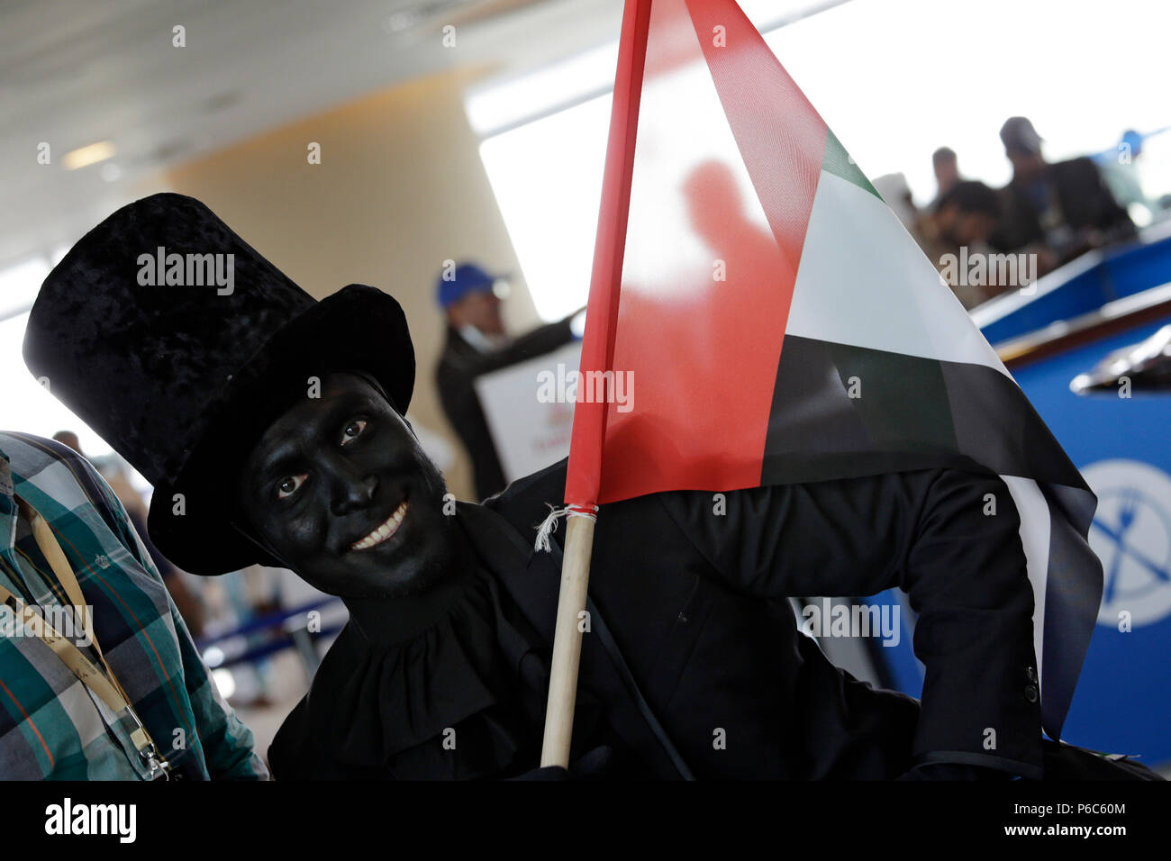 Dubai, verniciato di nero uomo con la bandiera nazionale degli Emirati Arabi Uniti Foto Stock