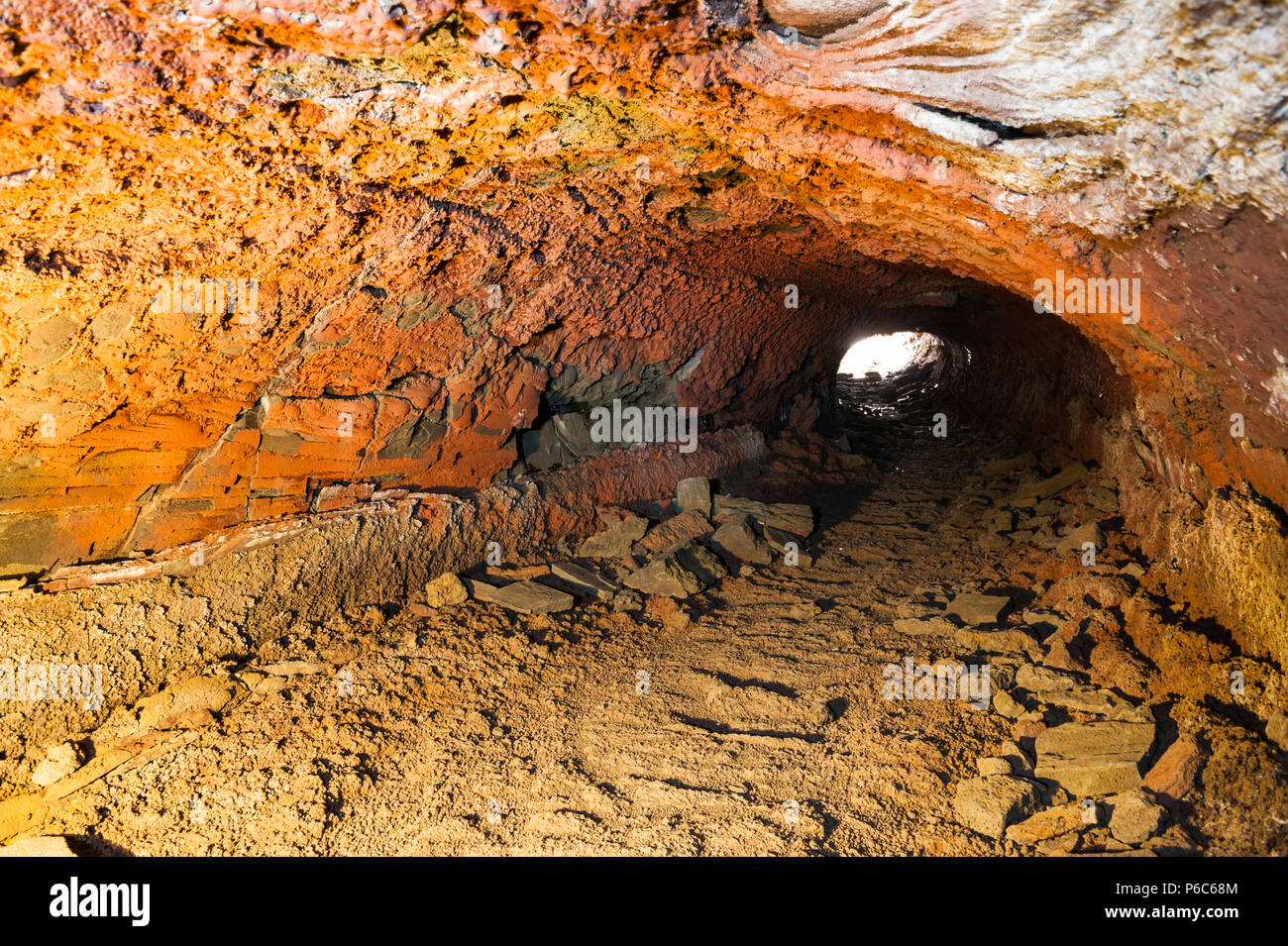 Rocce scoscese formando una grotta di lava illuminato dalla luce artificiale, acquisite in un lungo tempo di esposizione contrasty offre colori arancione, Islanda aprile 2018 Foto Stock