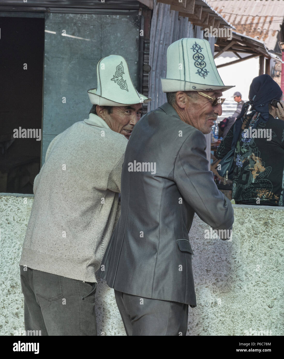 Gli uomini del Kirghizistan con kalpak cappelli a domenica il mercato degli animali, Karakol, Kirghizistan Foto Stock