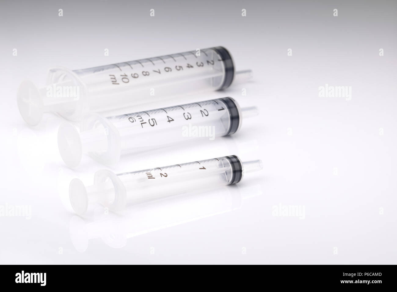 Cancellare siringhe di plastica isolato su uno sfondo bianco. Misurazione scientifica del concetto di modello di presentazione. Scientifico o strumento medico Foto Stock