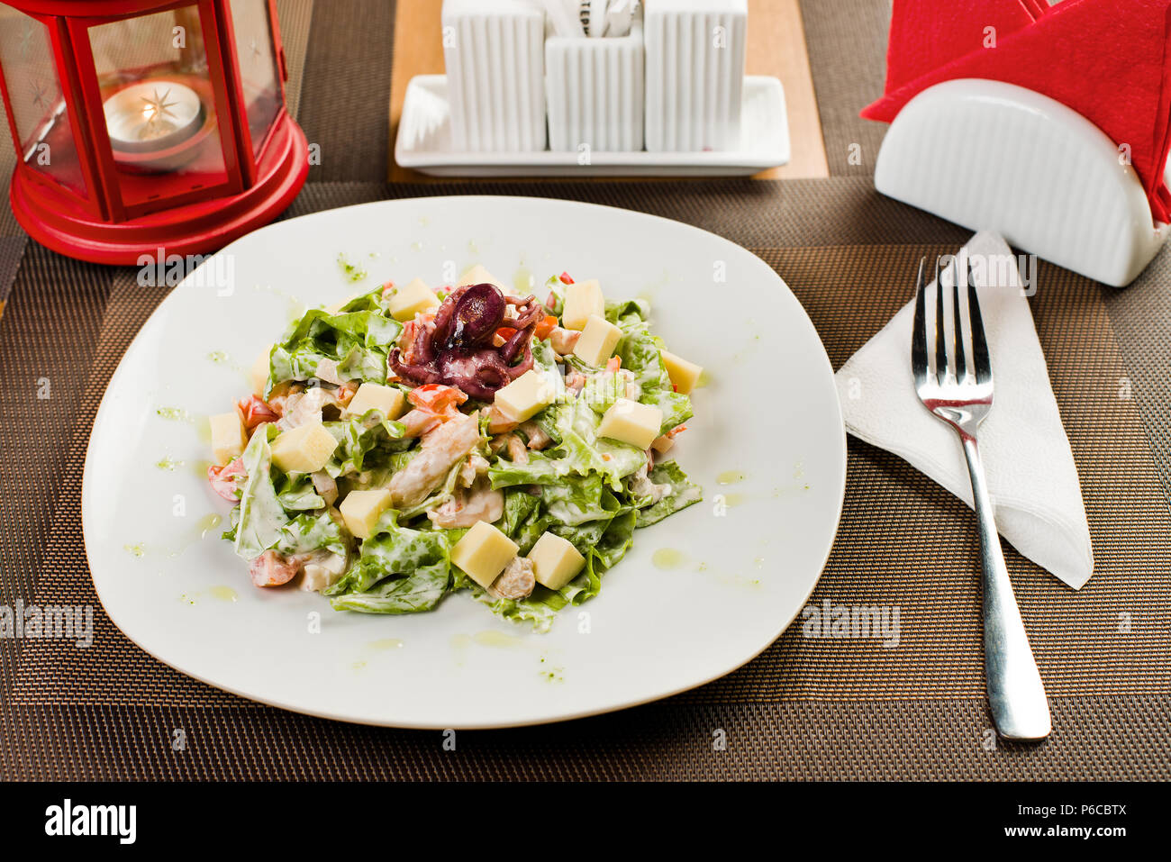 Ceramica piastra bianca con insalata di pesce e frutti di mare e verdure, sul tavolo nel ristorante Foto Stock