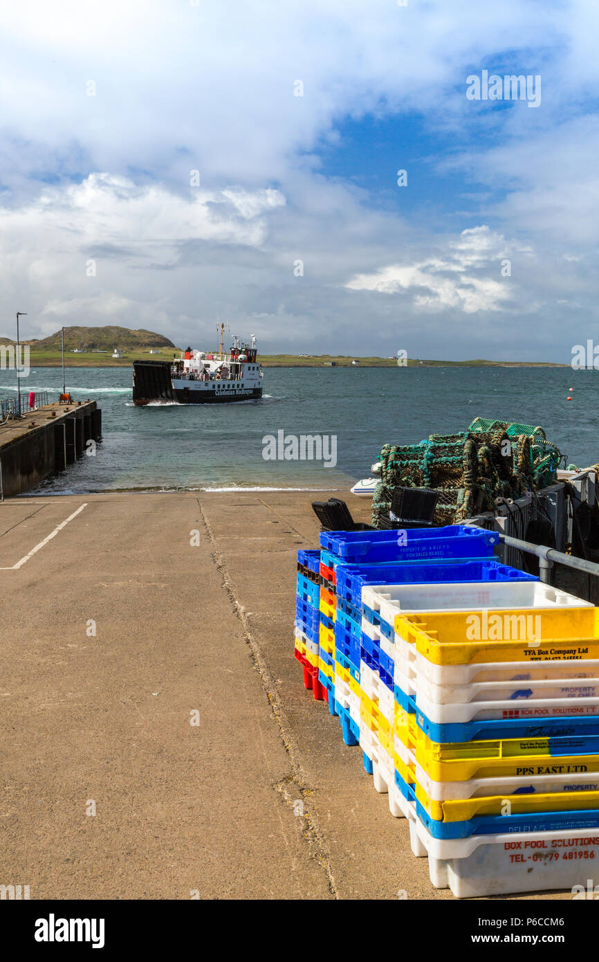L'Isola di Iona traghetto "Loch Buie' avvicinando il molo impilati con scatole di pesce a Fionnphort sull'Isle of Mull, Argyll and Bute, Scotland, Regno Unito Foto Stock