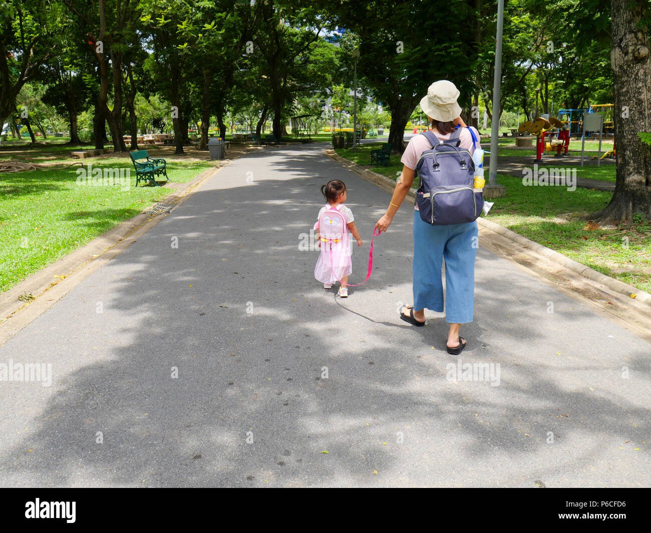 Asian mamma e bambina sono a piedi nel parco. Foto Stock