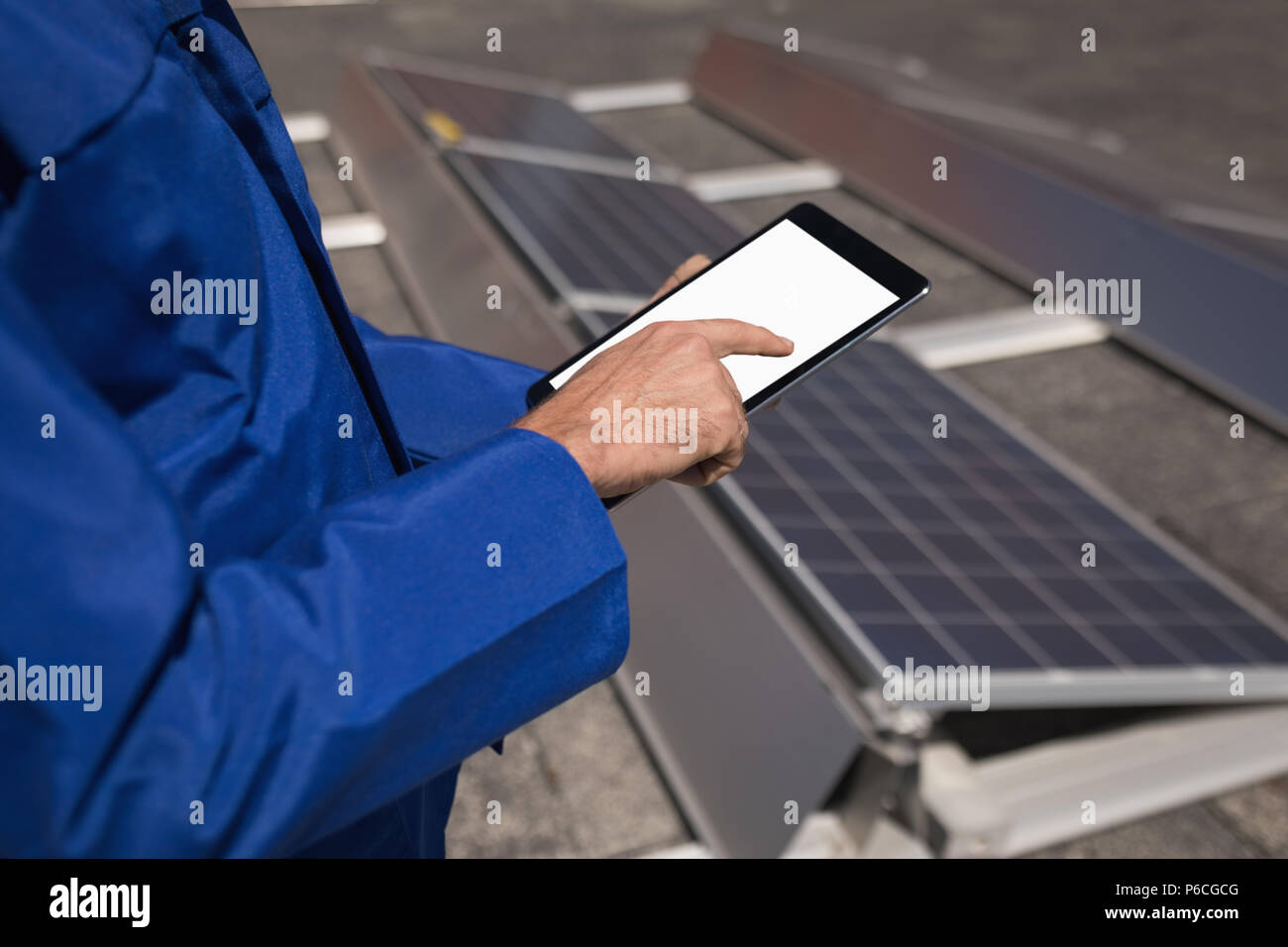 Lavoratore di sesso maschile con tavoletta digitale alla stazione solare Foto Stock
