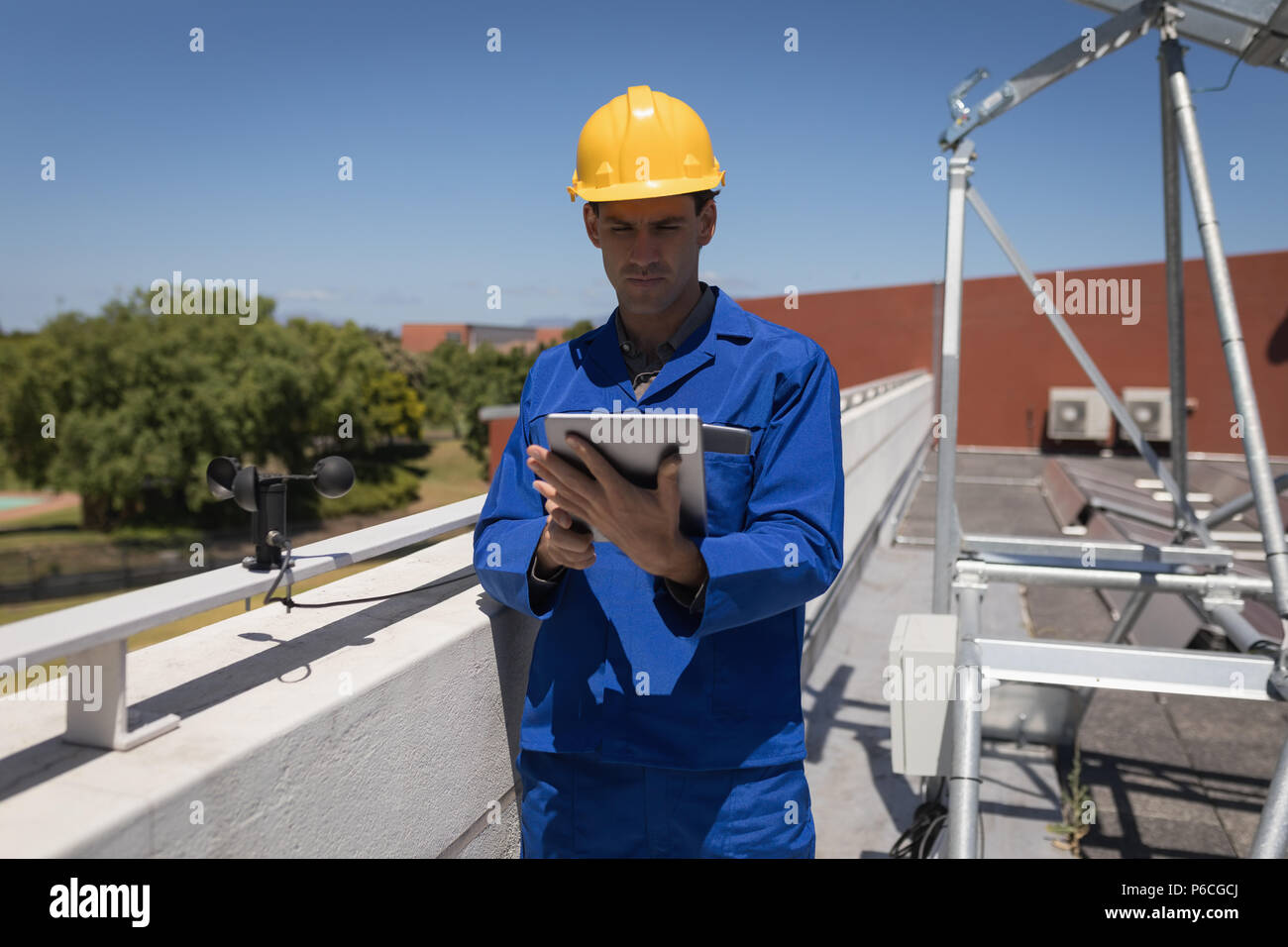 Lavoratore di sesso maschile con tavoletta digitale alla stazione solare Foto Stock