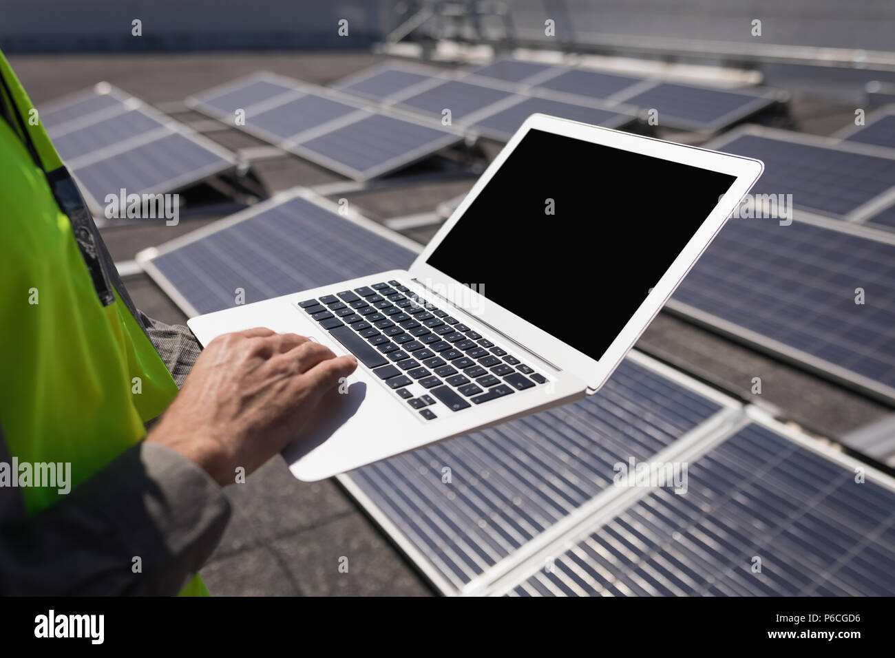 Lavoratore di sesso maschile con computer portatile presso la stazione solare Foto Stock
