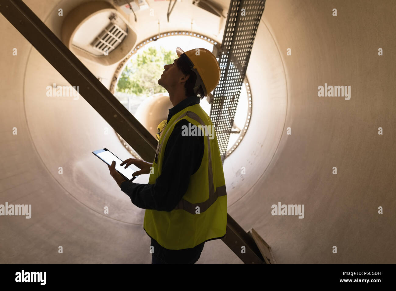 Lavoratore di sesso maschile con tavoletta digitale mentre esaminando un tunnel in calcestruzzo Foto Stock