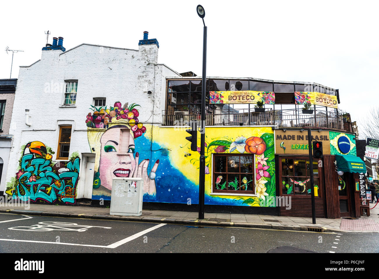 London, England Regno Unito - Dicembre 31, 2017: Bar con graffiti di un volto di una donna circondata da motivi tropicali a Camden High Street in Camden Lock o Foto Stock