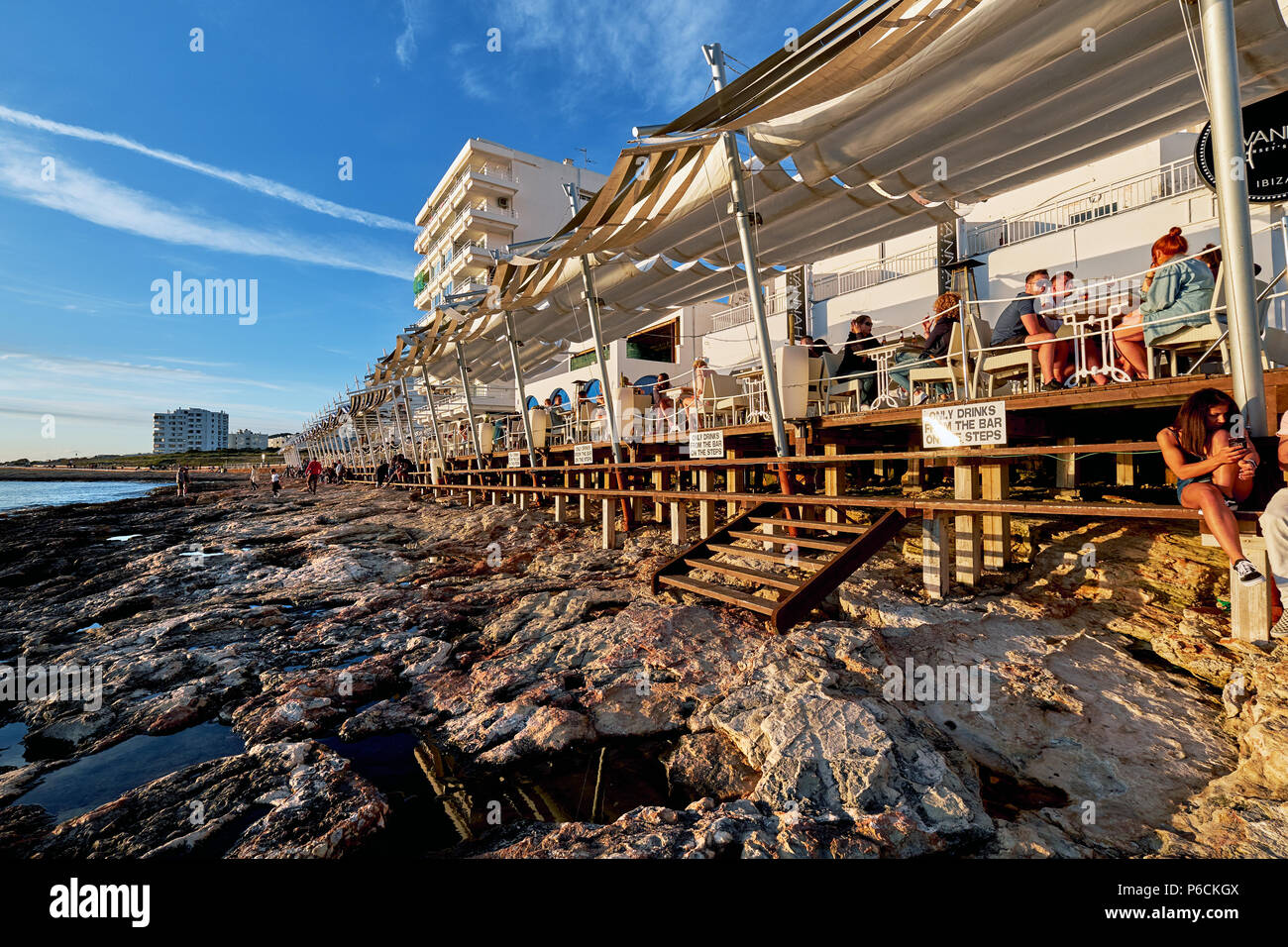 Isola di Ibiza, Spagna - 1 Maggio 2018: una folla di gente che soddisfano il tramonto dalla terrazza fronte mare di Cafe Del Mar. Questo luogo è famoso per le viste al sole Foto Stock