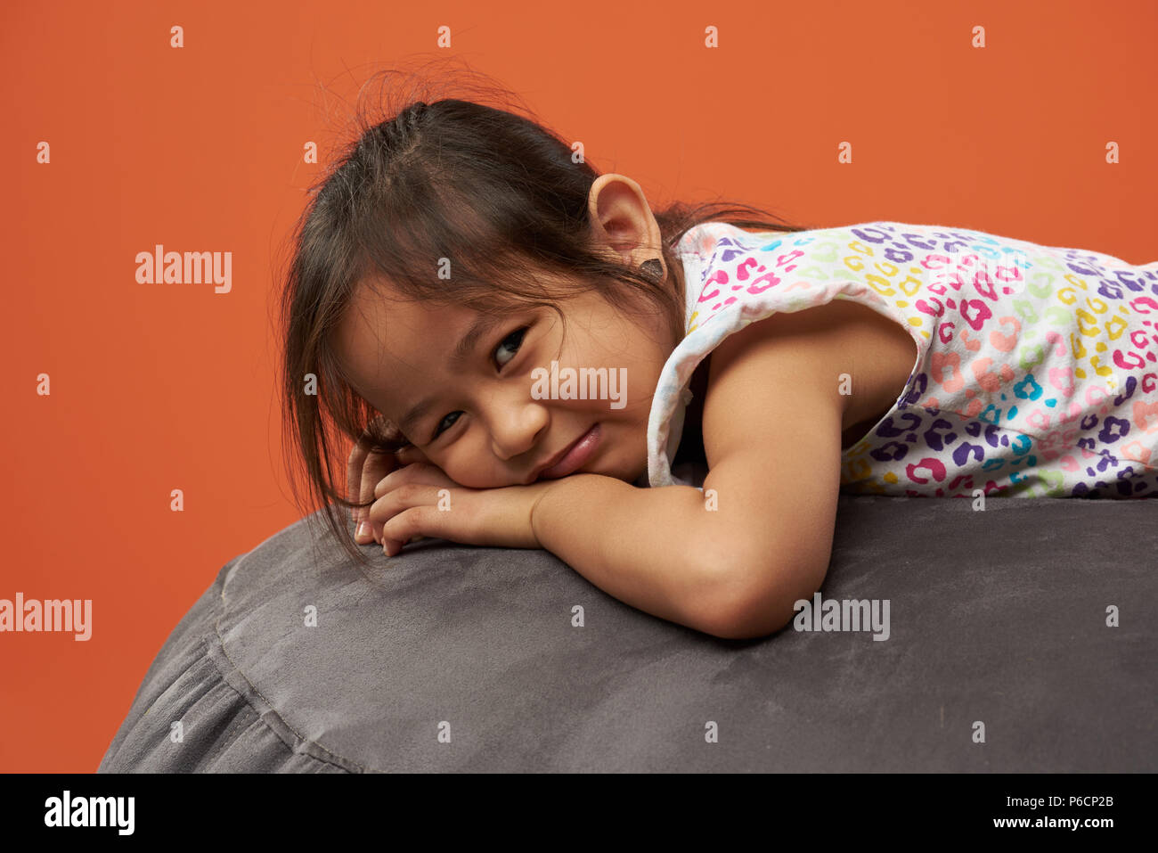Ritratto di triste ragazza asiatica isolati su orange Colore di sfondo Foto Stock