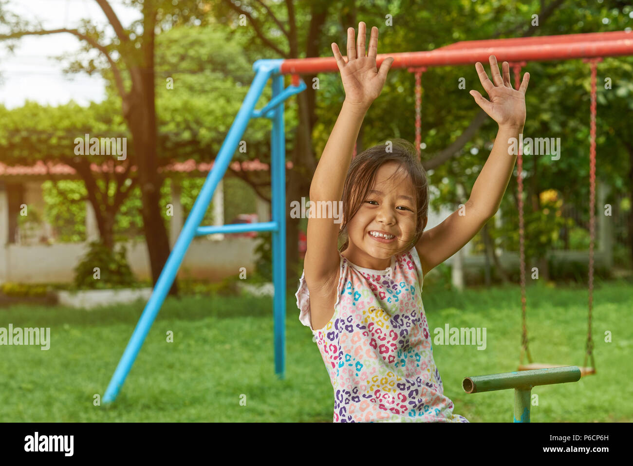 Ragazza asiatica divertirsi nel parco sulla soleggiata giornata luminosa Foto Stock