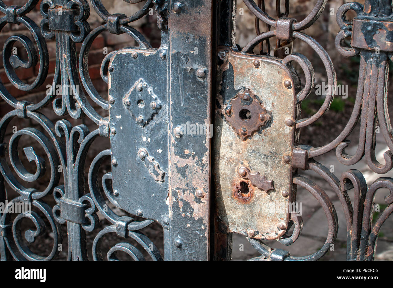 Vecchia serratura danneggiata sul giardino vintage porta in ferro con ornamenti decorativi closeup Foto Stock