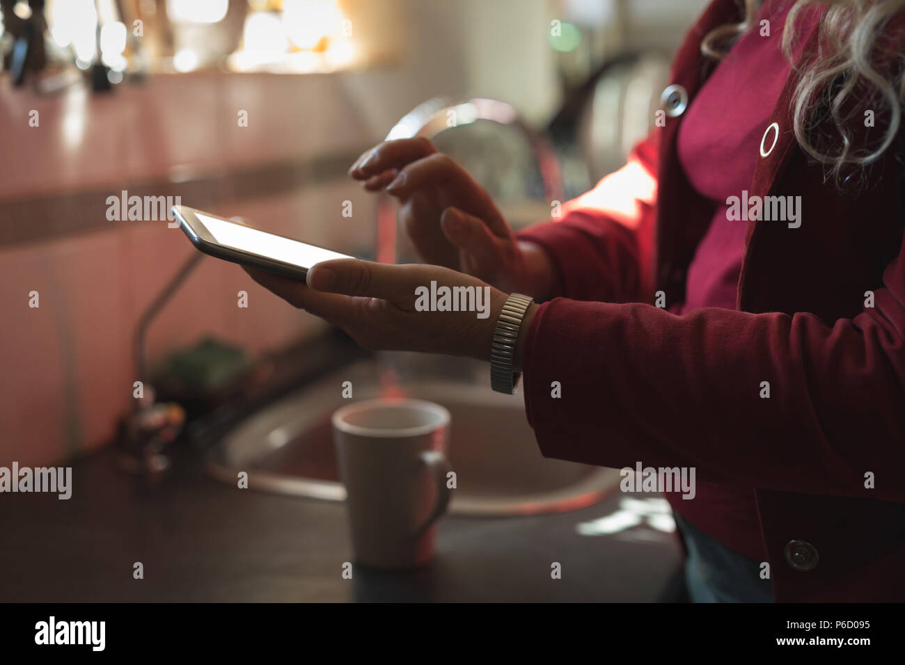 La sezione centrale della donna matura con tavoletta digitale Foto Stock