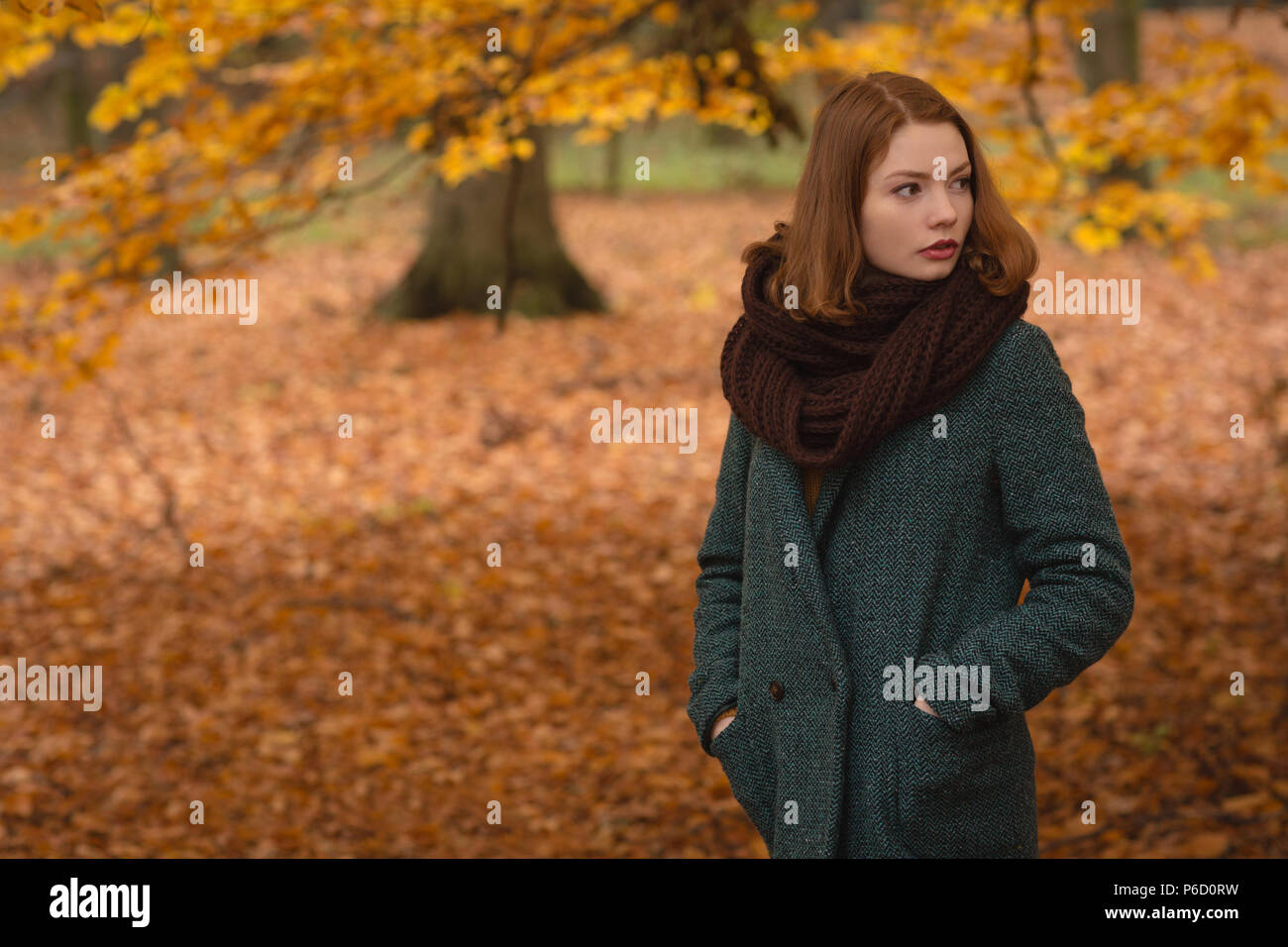Donna in piedi con le mani in tasca in posizione di parcheggio Foto Stock