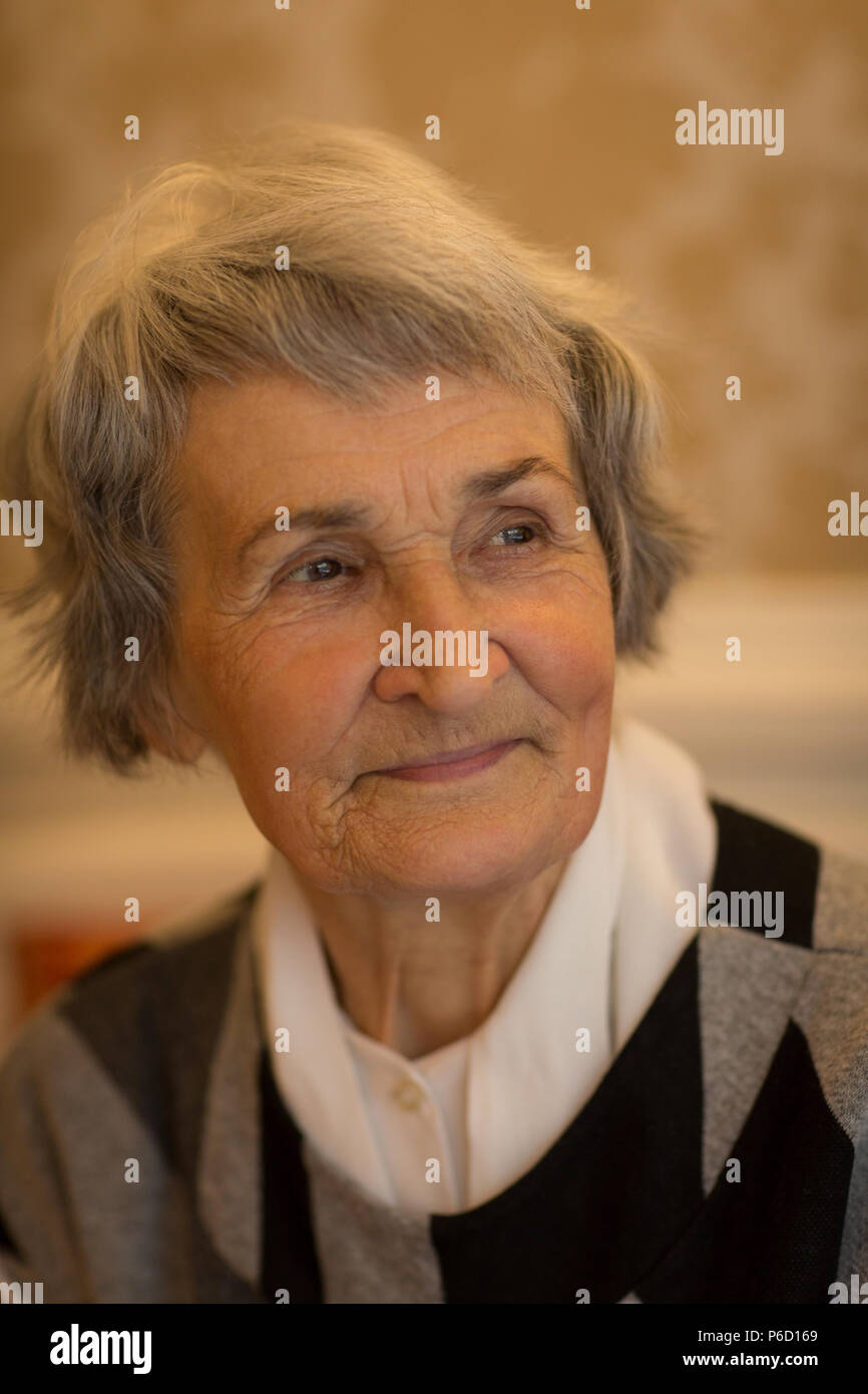 Senior donna sorridente a casa Foto Stock