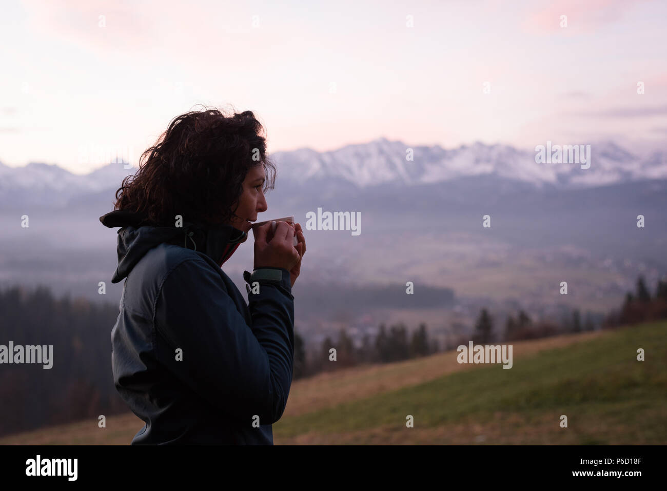 Premurosa donna avente un caffè a campagna Foto Stock
