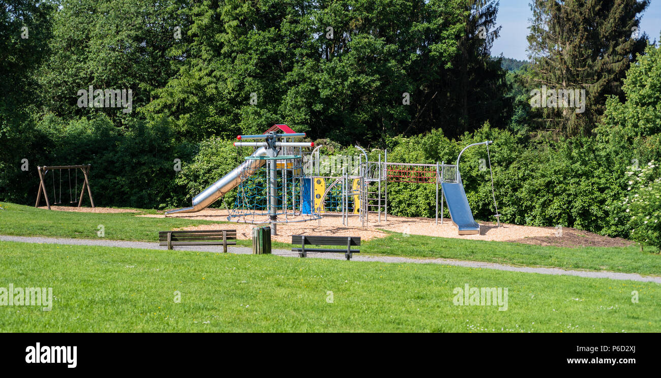 Parco giochi per bambini con scivolo, telaio di arrampicata e swing in natura Foto Stock