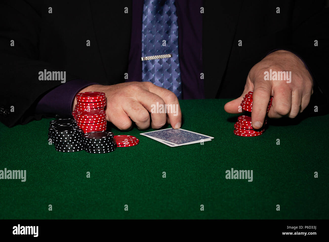 Scheda giocatore in business suit. Bicchieri e cravatta con chip di gioco su sfondo nero. Foto Stock