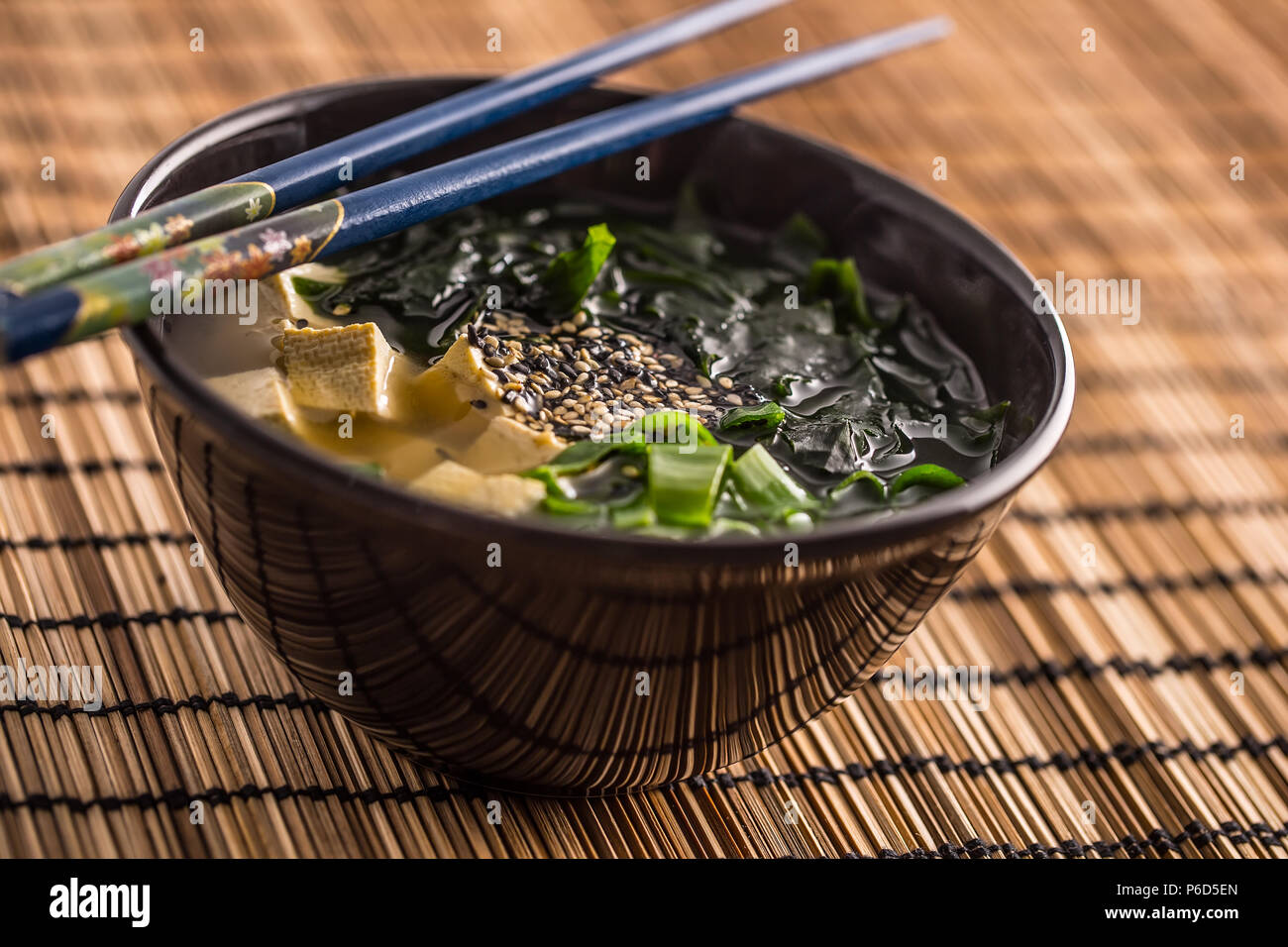 Giapponese tradizionale zuppa di miso con tofu alghe bacchette e giovani cipolla. Foto Stock