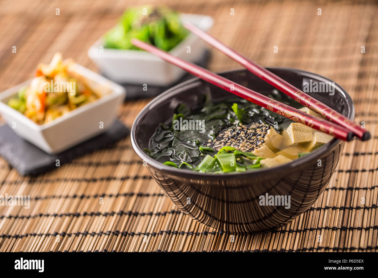 Giapponese tradizionale zuppa di miso con tofu alghe bacchette e giovani cipolla. Foto Stock