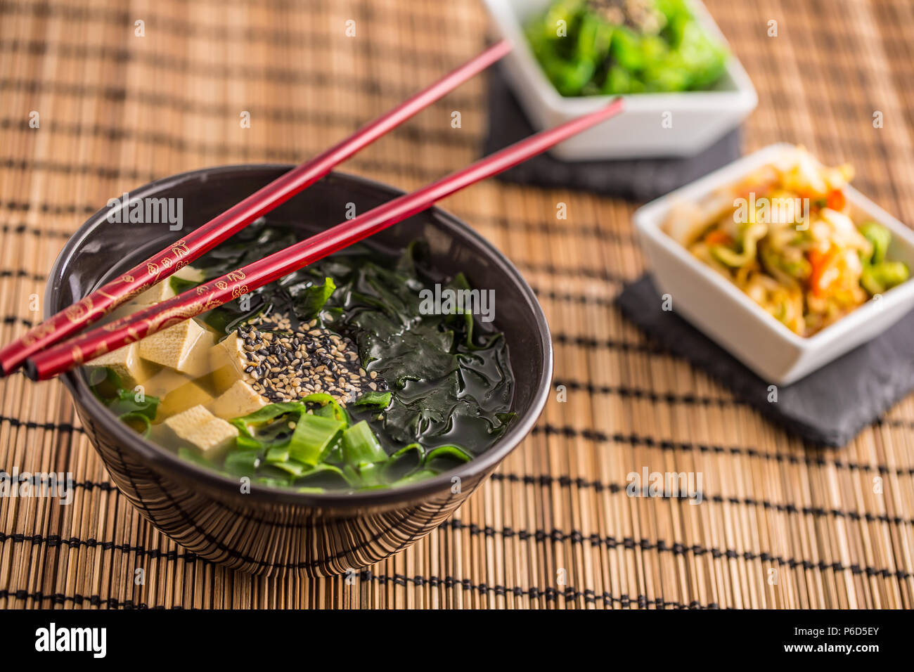Giapponese tradizionale zuppa di miso con tofu alghe bacchette e giovani cipolla. Foto Stock