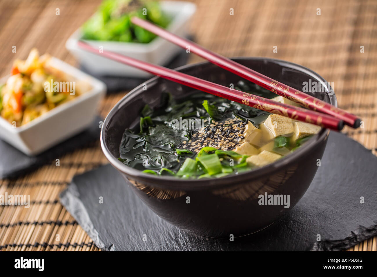 Giapponese tradizionale zuppa di miso con tofu alghe bacchette e giovani cipolla. Foto Stock