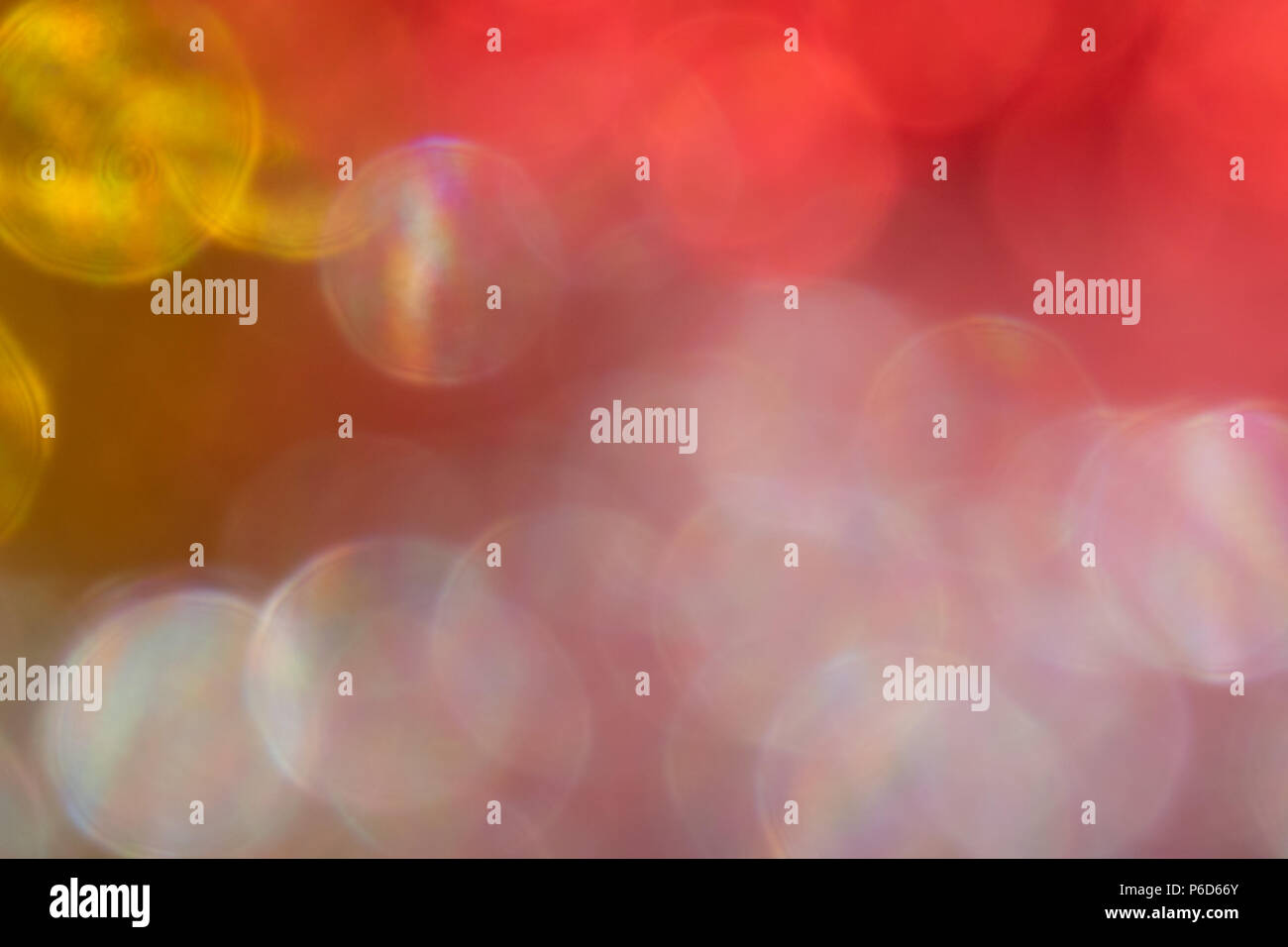 Abstract irridescent rossa e dorata sfondo bokeh, incandescente cerchi. Foto Stock