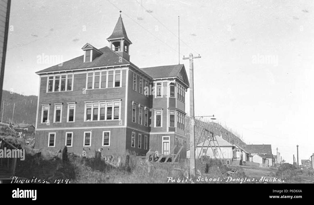 . Inglese: pubblico edificio scolastico, Douglas, ca. 1912 . Inglese: didascalia sull'immagine: scuola pubblica, Douglas, Alaska PH Coll 247.444 Douglas si trova entro la City & il Borough di Juneau, sulla costa nordorientale dell'Isola di Douglas. Il canale Gastineau è attraversato dal ponte Juneau-Douglas. Localmente, il Douglas area si riferisce all'estremità meridionale dell'isola (popolazione 2.000). Il più presto il nome registrato è stato Edwardsville, forse per H.H. Edwards, un minatore e residente. Douglas ha avuto origine nel 1881 al servizio delle attività estrattive, e divenne una città incorporata nel 1902. Anche fondata nel 1881, vicino a Treadwe Foto Stock