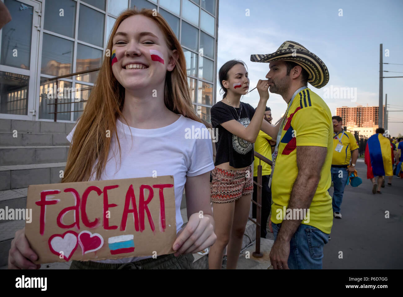 Giovani disegnare le bandiere delle squadre nazionali sulle facce dei tifosi di calcio in città di Kazan durante la Coppa del Mondo FIFA 2018 in Russia Foto Stock