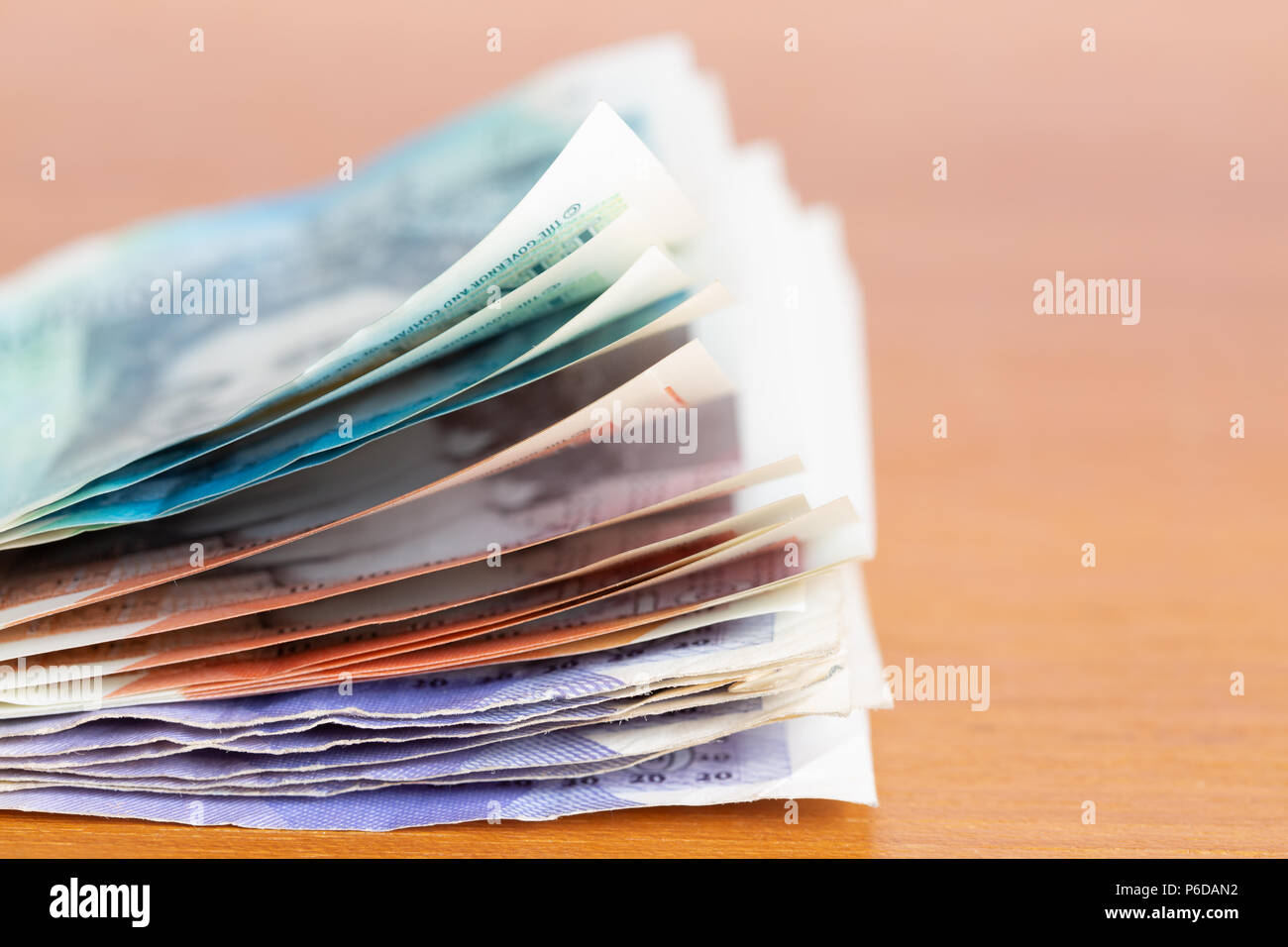 Pila di varie banca britannica note su un tavolo Foto Stock