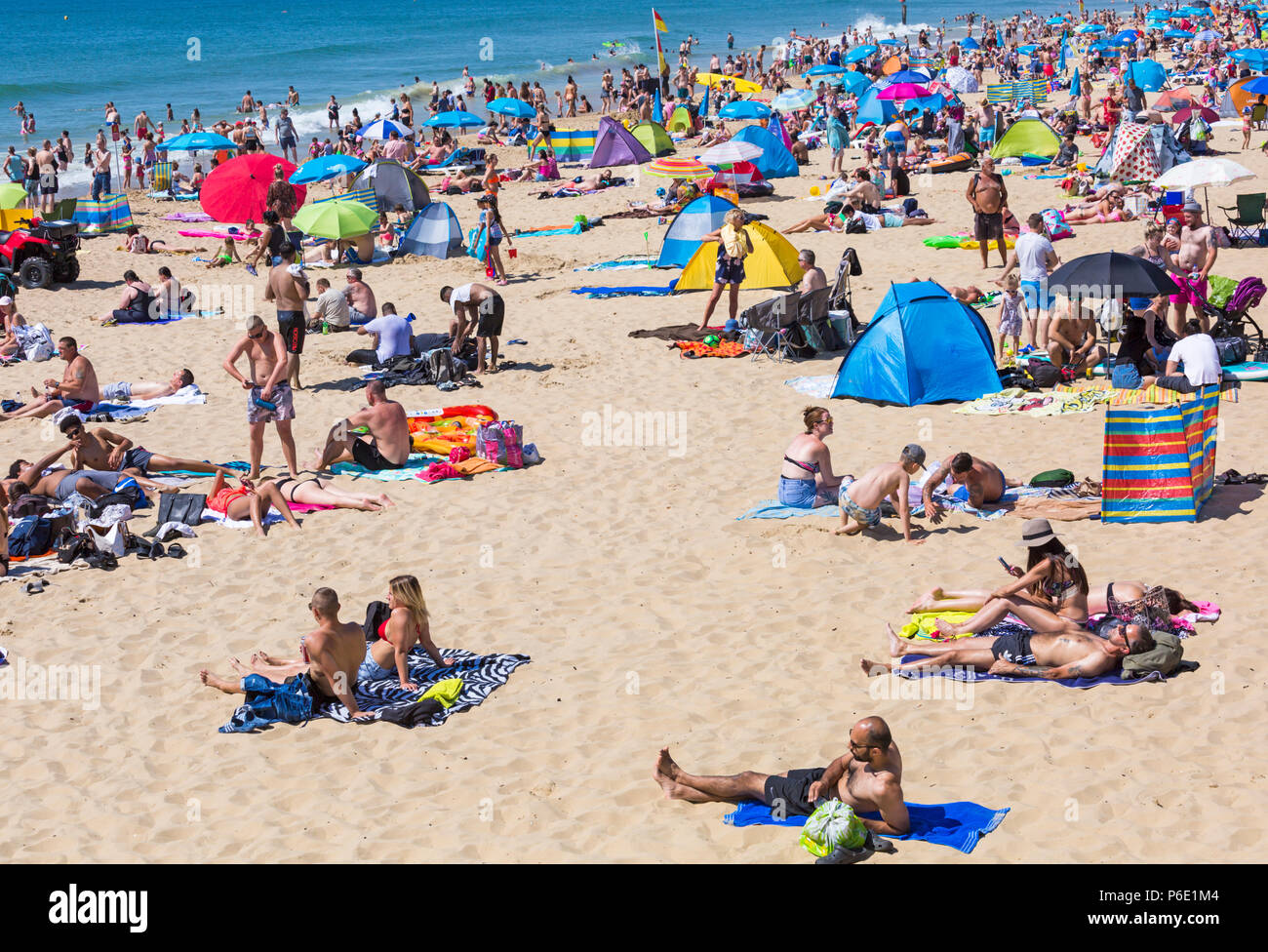 Bournemouth Dorset, Regno Unito. Il 30 giugno 2018. Meteo REGNO UNITO: l'ondata di caldo continua e un altro caldo giorno soleggiato a Bournemouth spiagge. A metà mattina e le spiagge sono sempre imballati e parcheggi pieni come sunseekers in testa al mare. Una lieve brezza rende il calore più sopportabile. Foto Stock