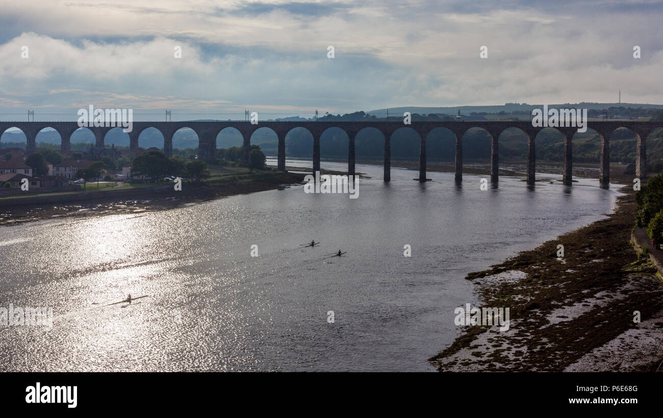 Kayakers al tramonto sul confine reale ponte che attraversa il fiume Tweed a Berwick-upon-Tweed in Northumberland, Inghilterra del Nord Est. Foto Stock