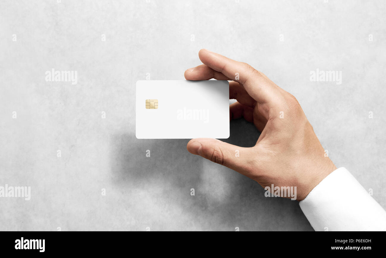 Mano azienda vuoto bianco carta di credito mockup con angoli arrotondati. Plain creditcard mock up modello con chip elettronico tenendo il braccio. Banca di plastica-display della scheda design anteriore. Branding aziendale. Foto Stock