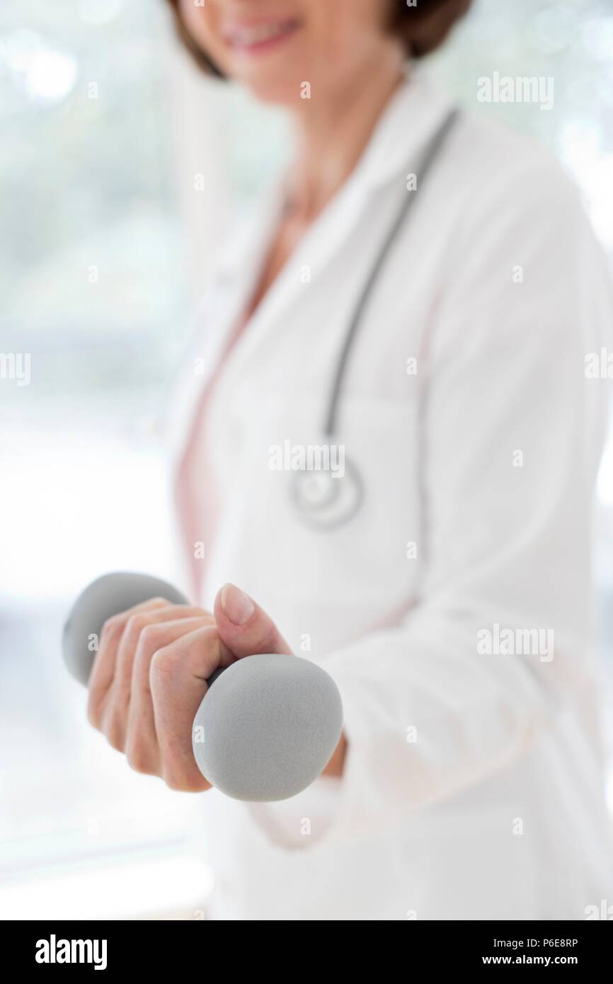 Medico donna tenendo la mano di peso. Foto Stock