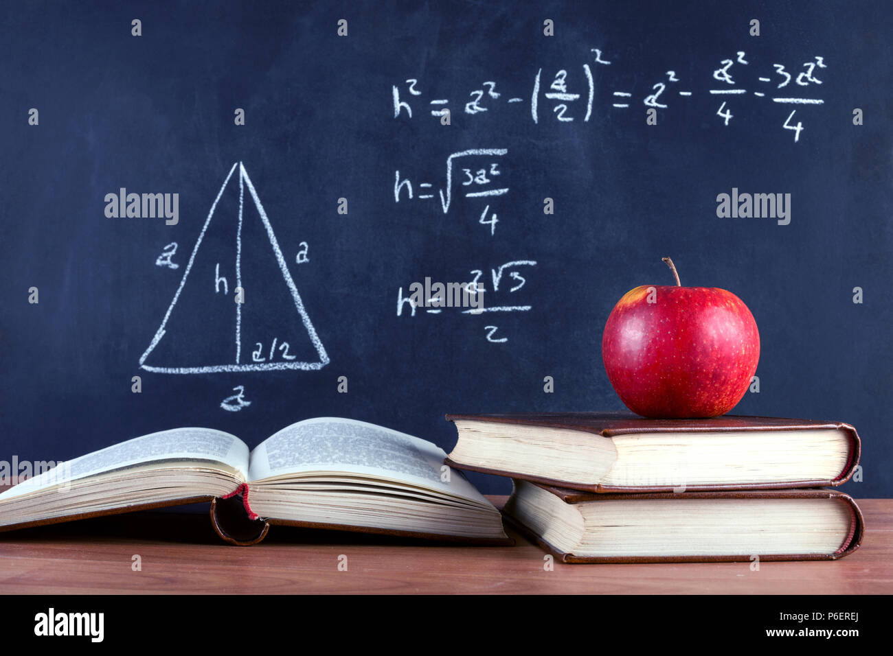 Red apple su libri e lavagna con Teorema di Pitagora scritto da chalk. Aula scolastica e il concetto di istruzione. Close up, il fuoco selettivo Foto Stock