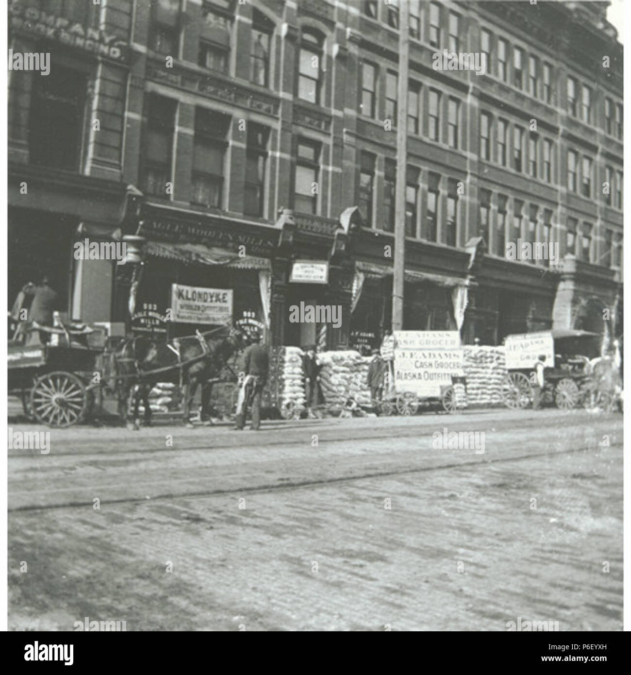 . Inglese: slitta trainata da cani team e forniture di data mining impilato sulla strada di fronte J. F. Adams, Alaska Outfitters store, Seattle, Washington, Marzo 1898 . Inglese: sul verso dell'immagine: Dogsled team di fronte J.F. Adams store. Alaska outfitters, Seattle Testo da Kiehl log: Anteriore di Adams store. Marzo, 1898. Album punto 2.103 soggetti (LCTGM): la prospezione di attrezzature e forniture soggetti (LCSH): slitte trainate da cani--Washington (stato)--Seattle carri;--Washington (stato)--Seattle; quartieri centrali degli affari--Washington (stato)--Seattle sulla base di un annuncio in un gennaio 1898 Post-Intelligencer, J.F. Adams è stato a 907 Primo Avenu Foto Stock