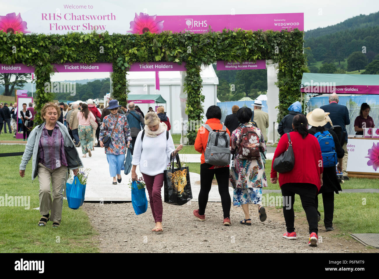 La gente a piedi & dall'entrata & uscita, proveniente & andando, in arrivo e in uscita - occupato showground, RHS Chatsworth Flower Show, Derbyshire, Inghilterra, Regno Unito. Foto Stock