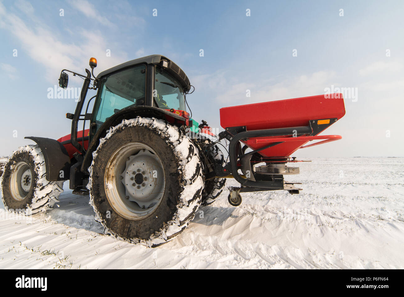 Contadino con il trattore la semina - semina in campi agricoli in inverno - neve Foto Stock
