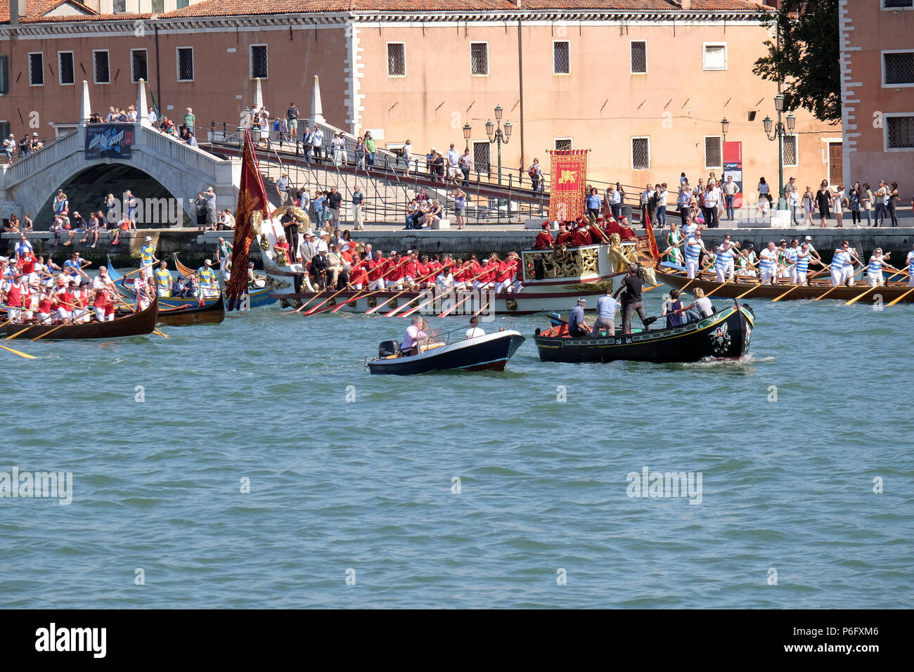 Barche piene di gente, musicisti e i rematori di arrivare alla storica festa della Festa della Sensa a Venezia dove la città si sposa con il mare a Venezia Foto Stock