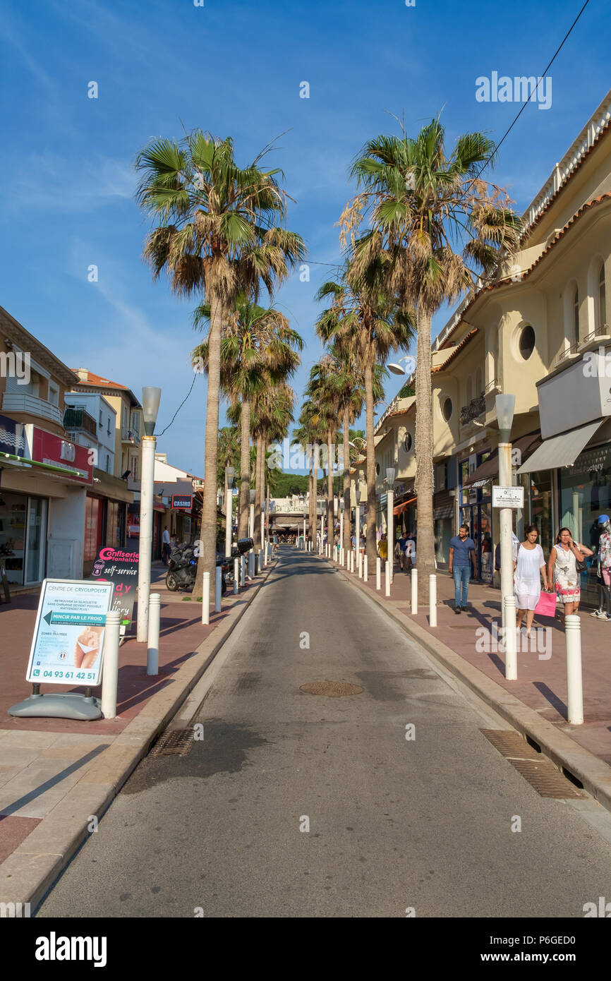 Negozi, ristoranti e palme lungo la passeggiata a mare di Juan les Pins, Antibes, Francia. Foto Stock
