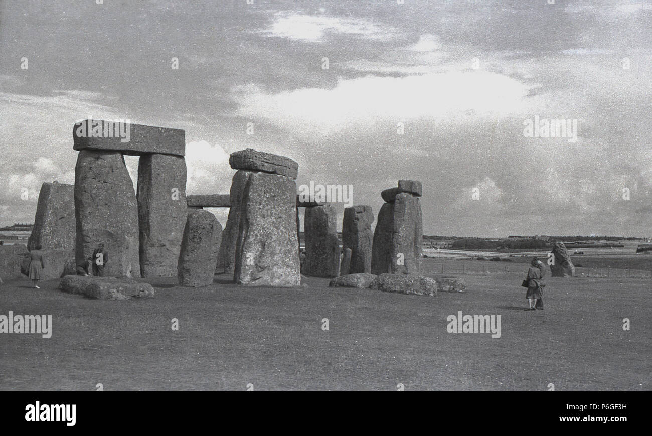 Degli anni Cinquanta, foto storiche di visitatori a Stonehenge, Wiltshire, Inghilterra, famosa in tutto il mondo momument preistorico. In questa epoca di visitatori all'antica anello di pietre permanente poteva camminare tra di loro è abbastanza liberamente, ma questo è stato arrestato nel 1977 come un risultato di "erosione" e ora è qualcosa che è consentito solo sulla cosiddetta " speciali visite accesso'. Foto Stock