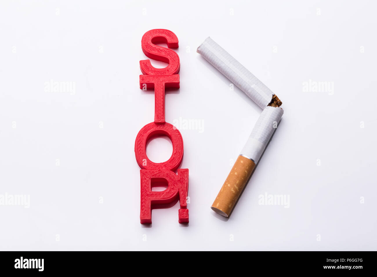 Vista in elevazione del rosso i blocchi cubici vicino a rotture di sigaretta su sfondo bianco Foto Stock