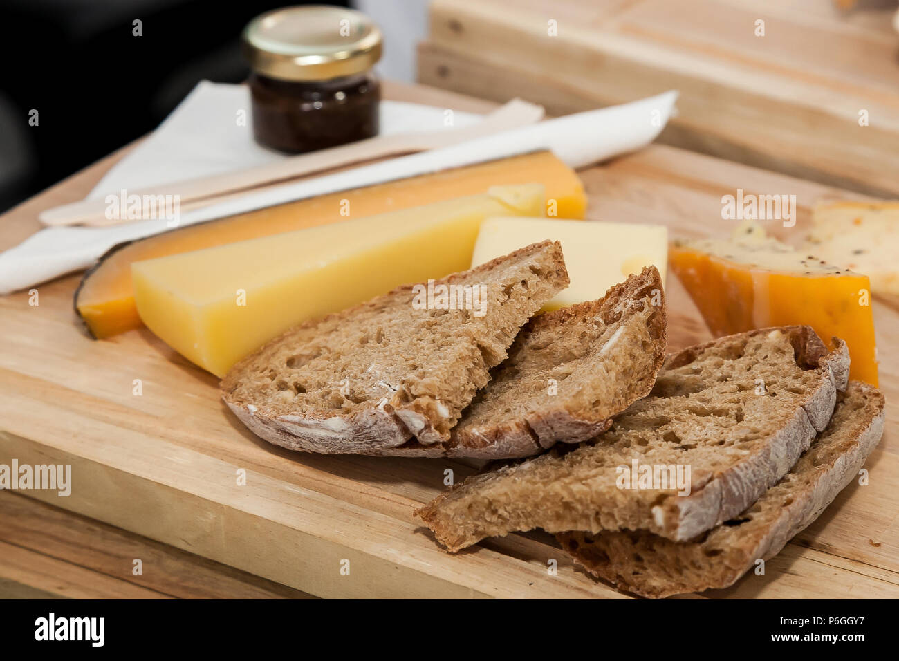 Fette di pane e formaggio diverse su una tavola di legno Foto Stock